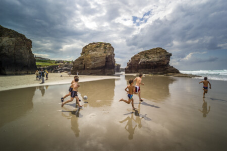 Boys playing soccer on the beach. 2004 Spain